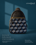 A Cross Lined crossbody bag made from reclaimed denim grunge, featuring a geometric 3D cube pattern in shades of blue and gray, with a black tyre tube top and gold zipper. The bag is displayed against a dark teal-blue background with soft window shadows.