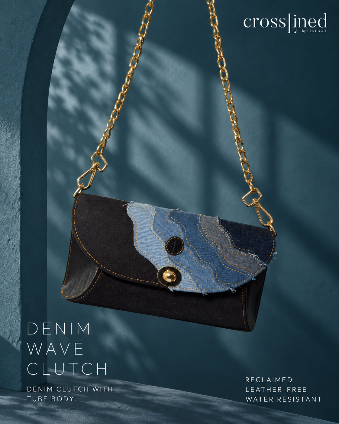 A Crosslined denim clutch bag with a gold chain strap, featuring a dark brown denim flap and a blue denim wave pattern, set against a dark teal background with leaf shadows.