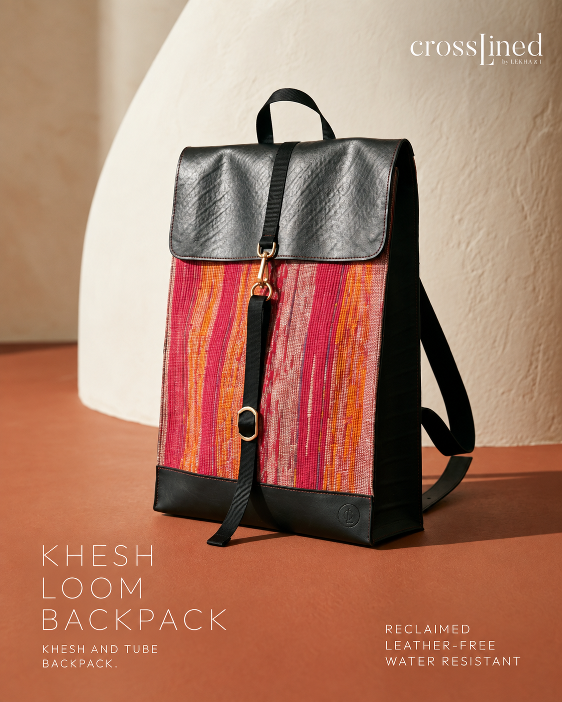 A Crosslined backpack with a textured black tyre tube top flap and base, a central black strap with a gold-tone buckle, and a vibrant reclaimed textile body featuring vertical stripes of pink, orange, and red. The backpack is displayed on a terracotta surface against a beige textured background.