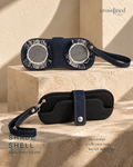 A pair of dark blue denim sunglasses holder cases shown in two views: one resting on a beige stone pedestal with circular mesh inserts, and another lying flat below with a strap closure. The brand name 'crossjined' appears in the top right, and 'SHADE SHELL SUNGLASSES HOLDER' is printed on the bottom left.