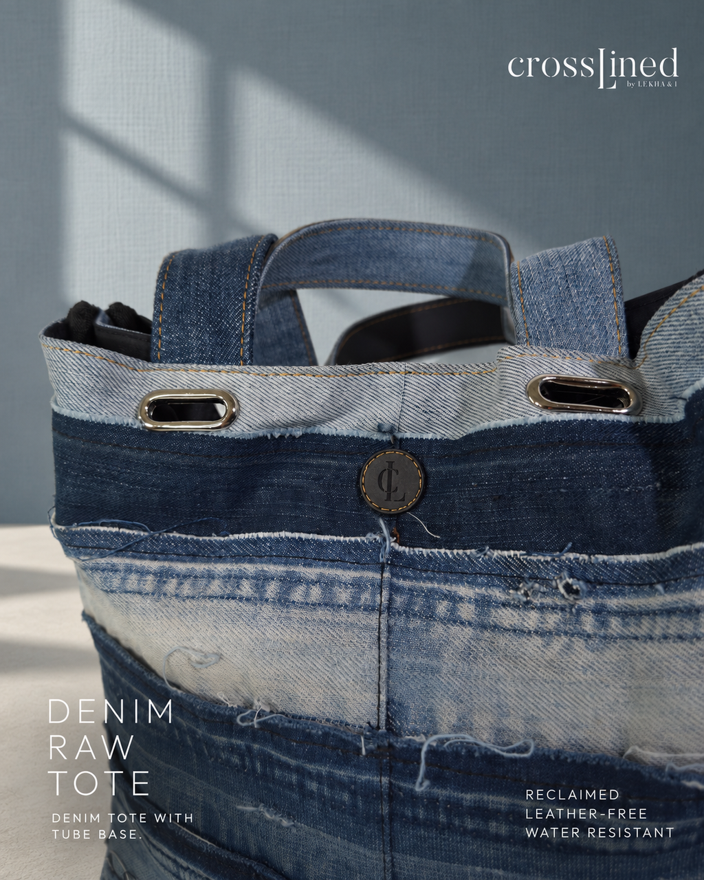 A denim raw tote bag made from reclaimed blue denim jeans, featuring dual top handles, metal grommets, and a button closure, shown against a textured blue-gray background with text overlays.