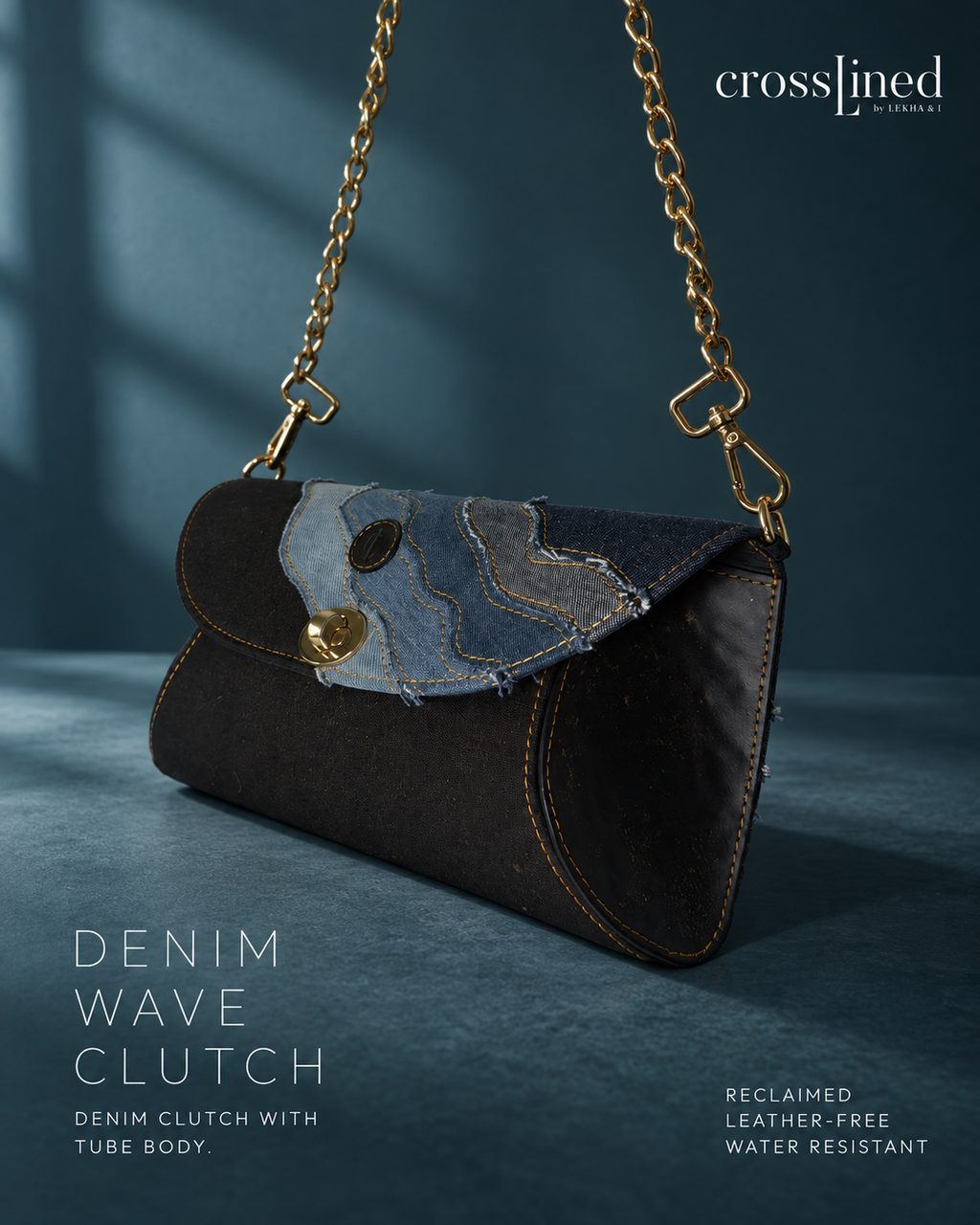 A dark denim wave clutch bag with a gold chain strap, shown on a dark blue textured background. The flap features a patchwork design with blue denim, black tyre tube and a circular black logo